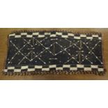 A Kuba cloth panel, the dark brown field with decorative trellis-pattern stitching & applied small