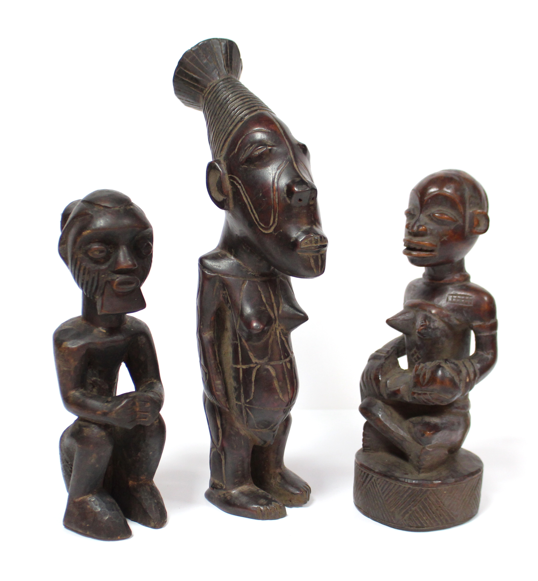 A Kongo carved wood maternity figure seated cross-legged, an infant on her lap, 8¼”; a similar