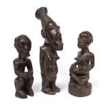 A Kongo carved wood maternity figure seated cross-legged, an infant on her lap, 8¼”; a similar