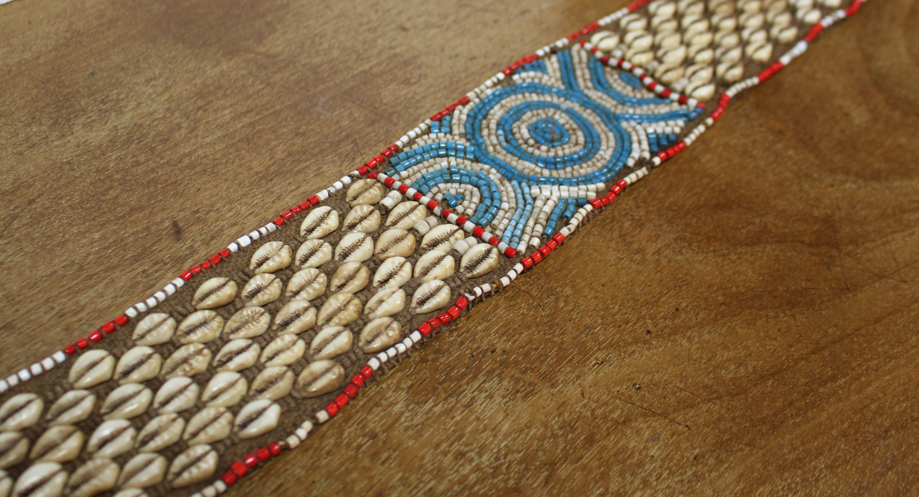 A Kuba woven raffia long belt with diagonal rows of applied cowrie shells either side of a central - Image 2 of 6