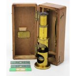 A brass student’s microscope, 6¼” high, in fitted mahogany case, bears label “E. Lennie,