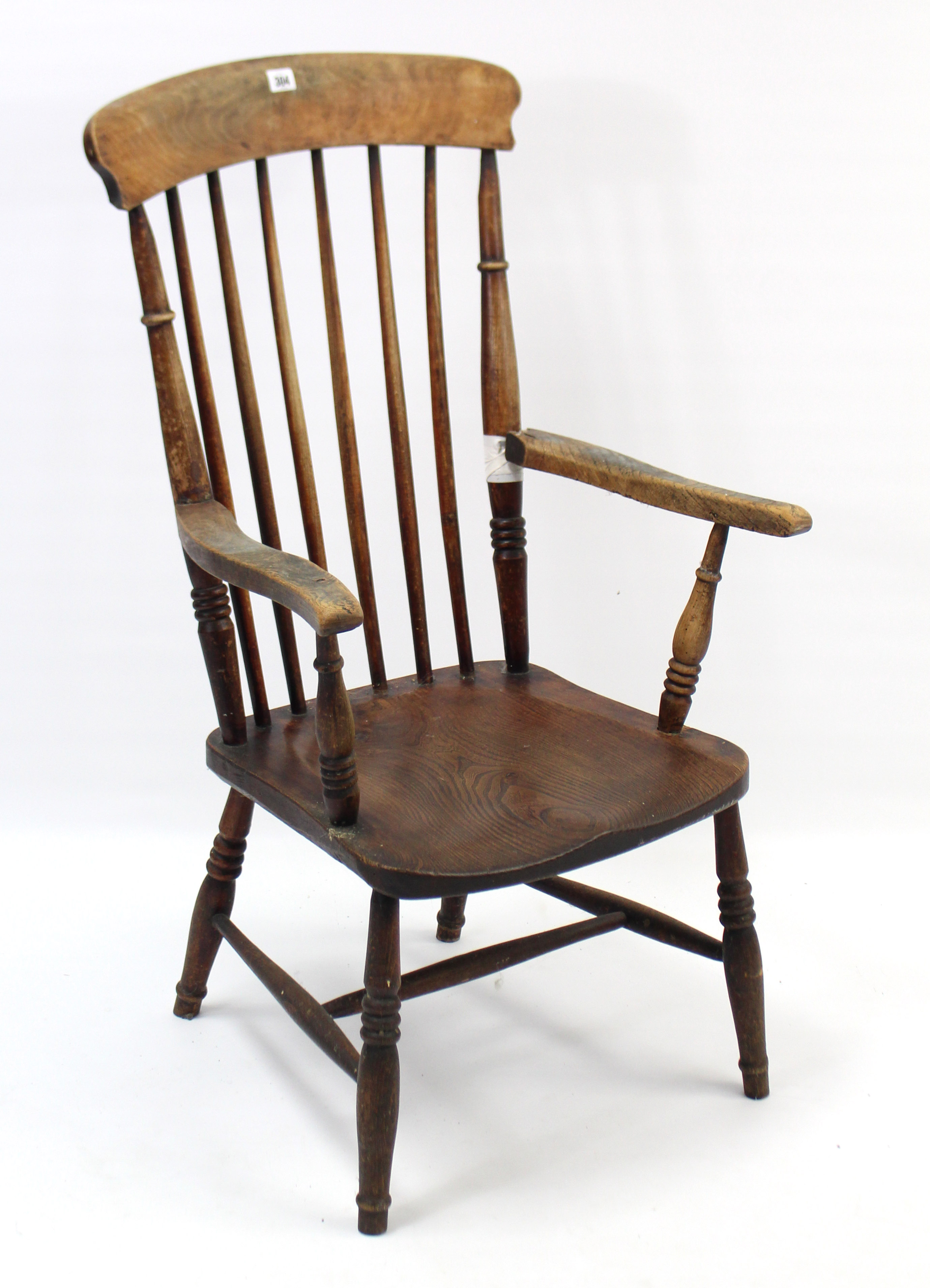 A late 19th century comb-back elbow chair with hard seat, & on turned legs with spindle