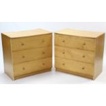 A pair of maple-finish chests, each fitted three long drawers with turned knob handles (slight