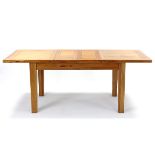 A modern light oak extending dining table with pull-out action, two removable leaves, & on square