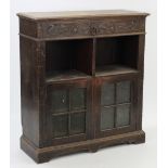 An early 20th century carved oak side cabinet, fitted frieze drawer above two open shelves with