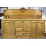 A VICTORIAN PINE INVERTED BREAK-FRONT SIDEBOARD with open shelf to the shaped & carved low-stage