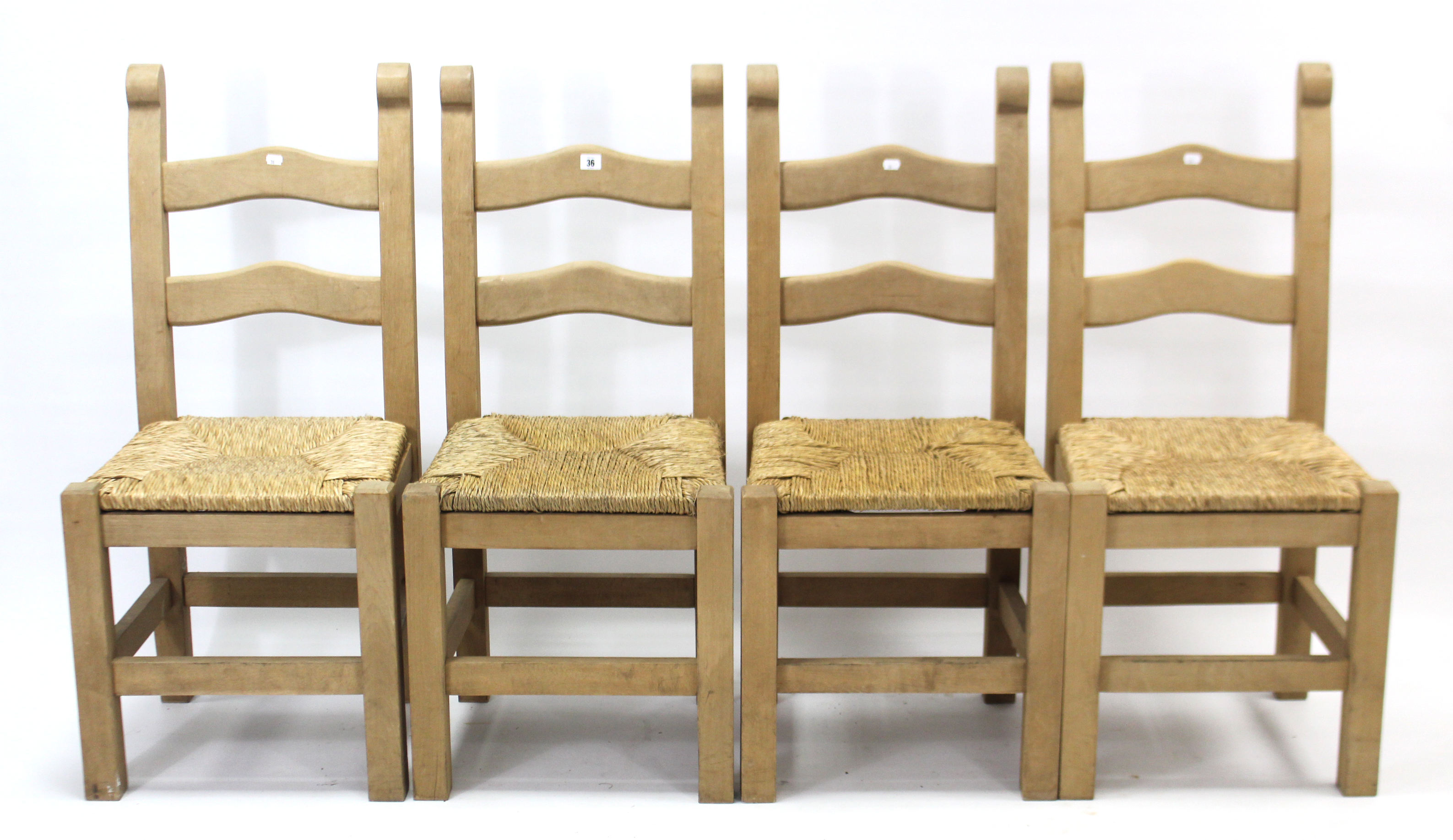 A set of four beech ladder-back dining chairs with woven rush seats, & on square legs with plain