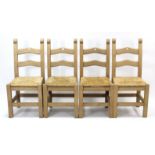 A set of four beech ladder-back dining chairs with woven rush seats, & on square legs with plain