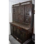 A continental carved hardwood tall cabinet, the upper part with spindle-rail cornice & enclosed by