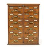 An early 20th century small oak office cabinet, bears label “J. Taylor, Dublin”, fitted two ranks of