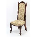 A 19th century carved beech nursing chair, with padded back & sprung seat upholstered floral
