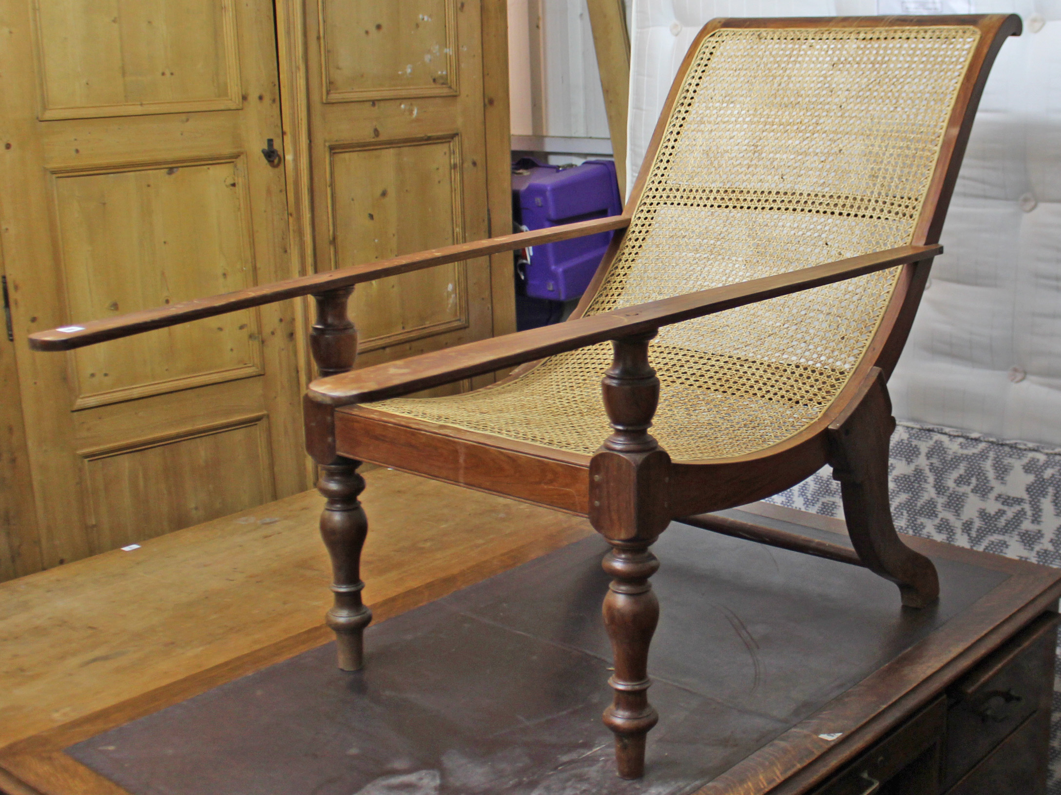 A teak plantation chair inset woven-cane panel to the all-in-one seat & back, & on baluster-turned