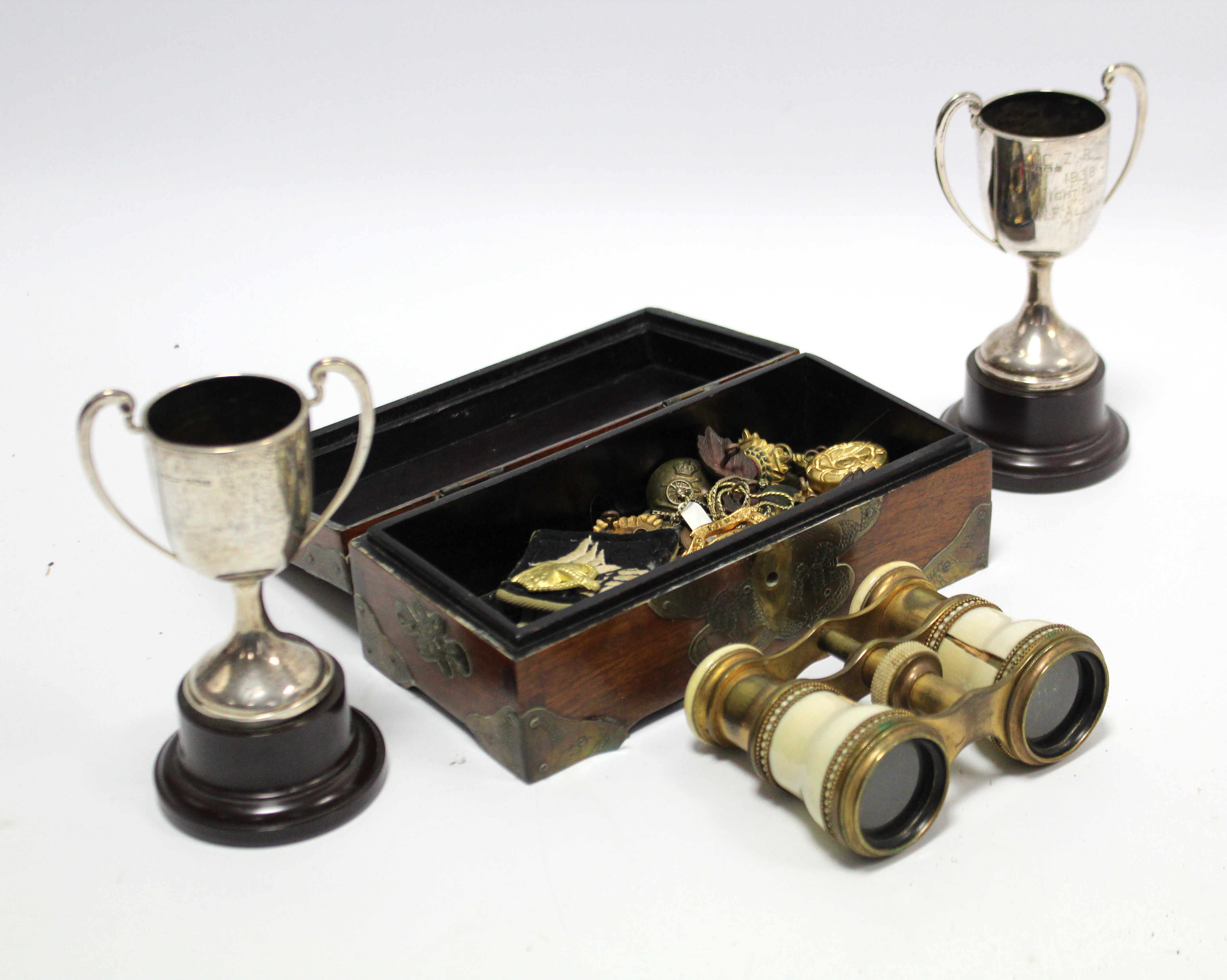 Two silver two-handled trophy cups; a pair of brass opera glasses; various military tunic