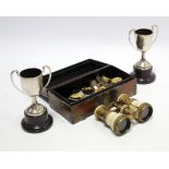 Two silver two-handled trophy cups; a pair of brass opera glasses; various military tunic