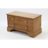 A pine dwarf chest fitted two short & one long drawer with turned knob handles, & on shaped plinth