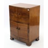 A mid-20th century walnut bow-front cabinet, enclosed by two pairs of panel doors & on bracket feet,