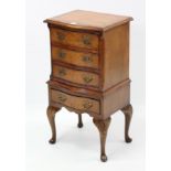 A burr-walnut serpentine-front bedside chest, fitted four long drawers &on short cabriole legs