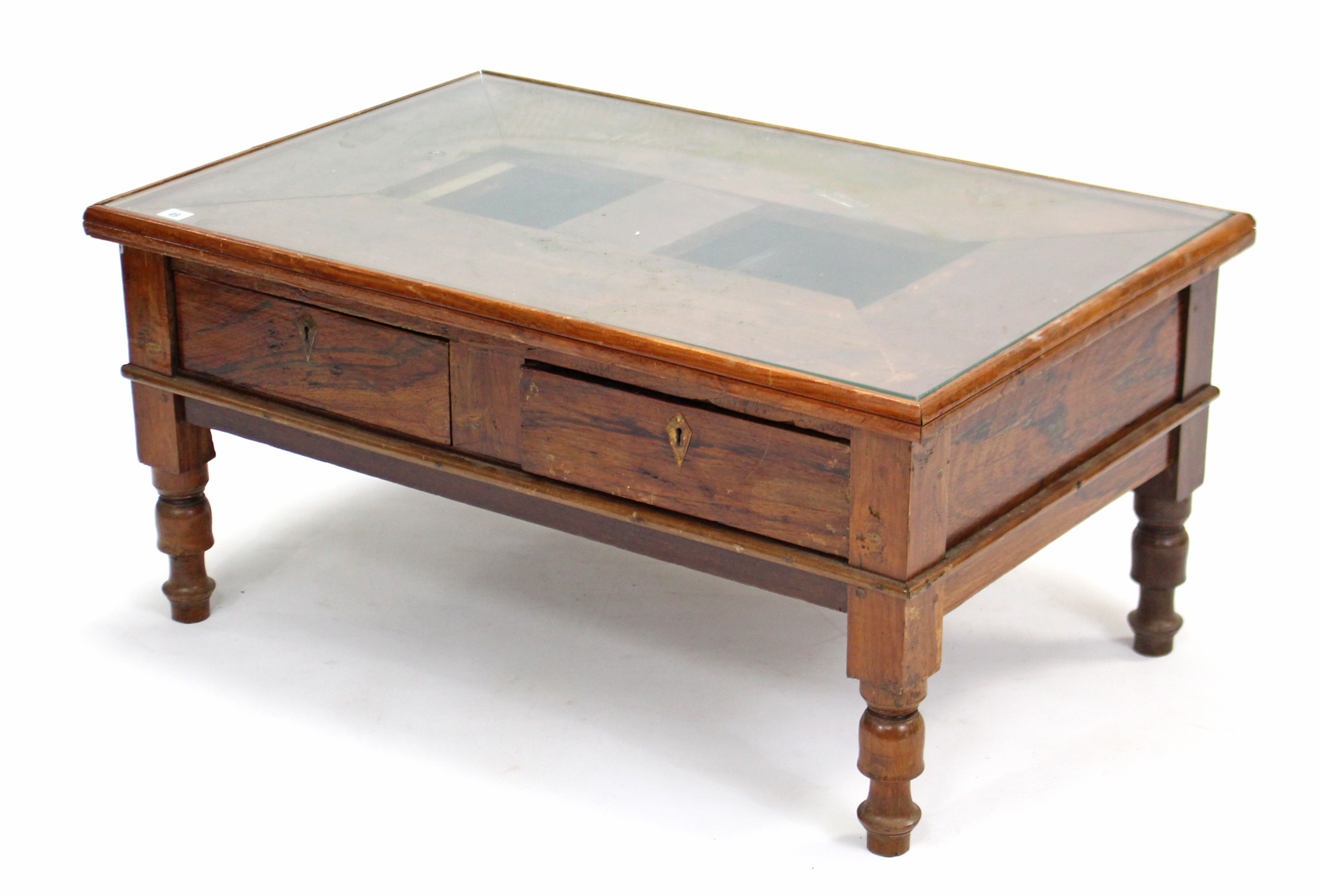 A teak low coffee table inset plate-glass to the rectangular top, fitted two frieze drawers, & on