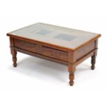 A teak low coffee table inset plate-glass to the rectangular top, fitted two frieze drawers, & on