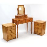 A pair of pine three drawer bedside chests, 18” wide; a pine dressing table, 33¾” wide, with mirror;