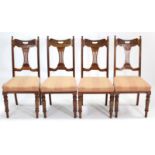 A set of four late Victorian carved walnut splat-back dining chairs with padded seats, & on turned