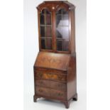 A Queen Anne-style walnut bureau-bookcase, the upper part with three adjustable shelves enclosed