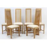 A set of six beech-finish rail-back dining chairs with padded seats, & on square legs with plain