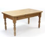 A pine kitchen table with rounded corners to the rectangular top, & on four turned legs, 60” x 36”.