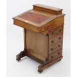 A Victorian walnut davenport, inset gilt-tooled crimson leather to the hinged sloping-front,