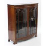 An Edwardian mahogany bow-front china display cabinet, with three adjustable shelves enclosed by