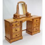 A pine kneehole dressing table, fitted three long drawers to each pedestal, on shaped plinth base,