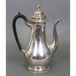 An 18th century-style coffee pot of baluster shape with ebonised scroll handle, hinged lid & on
