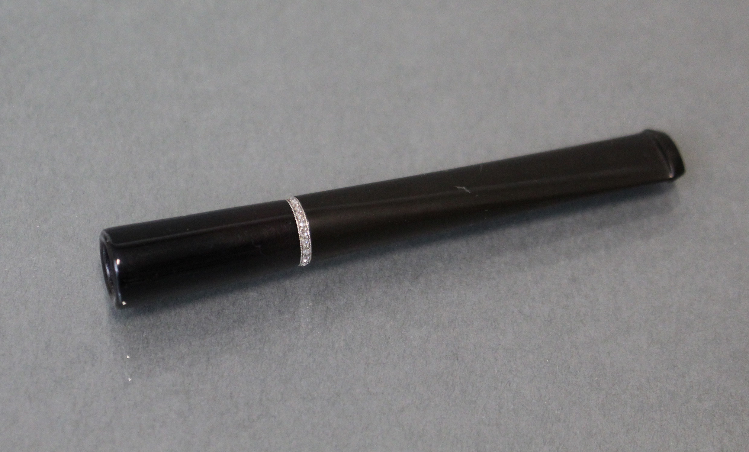 An Asprey diamond-set cigarette holder, the plain sleek black body with narrow white metal band - Image 2 of 3