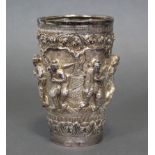 A Burmese silver beaker of tapered cylindrical form, with embossed decoration of figures in