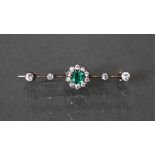 An emerald & diamond knife-edge bar brooch, the central cushion –shaped emerald approximately 0.4