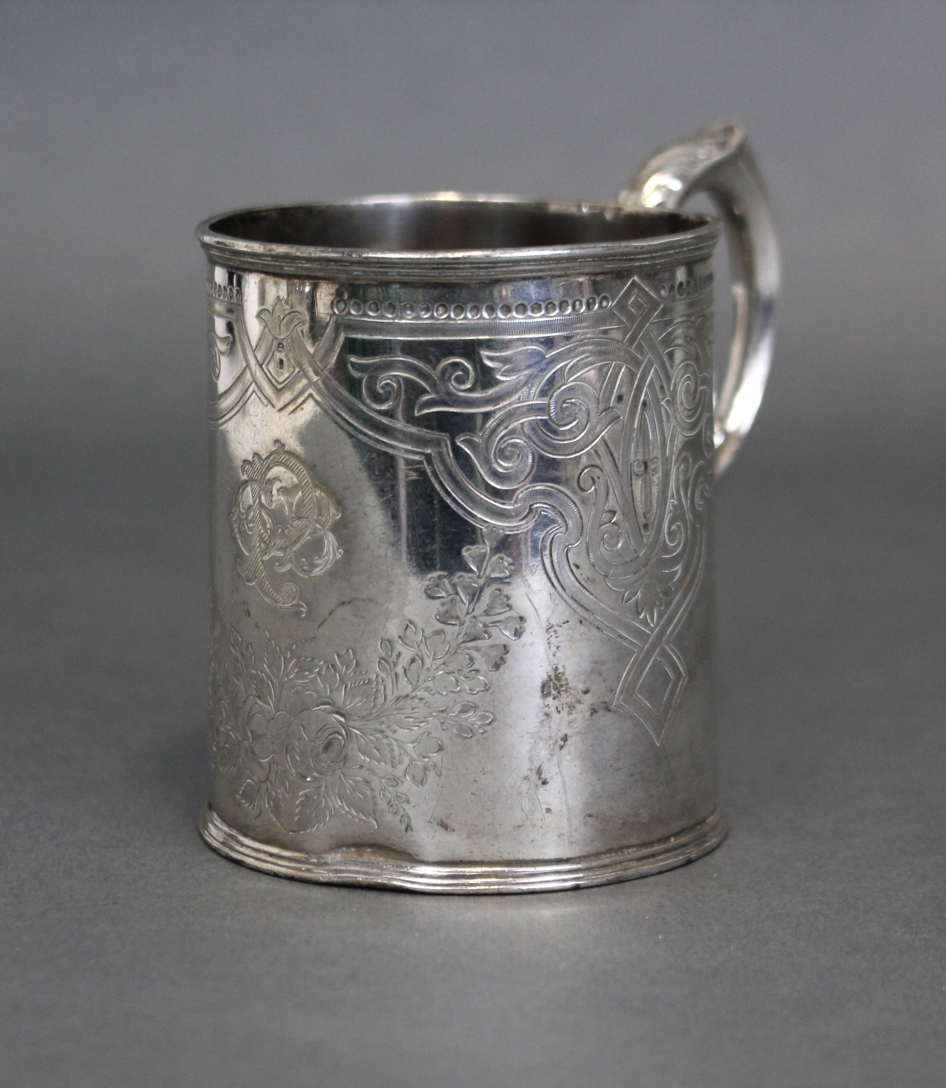 A Victorian silver cylindrical mug with engraved decoration, shaped scroll handle & reeded foot; - Image 2 of 3