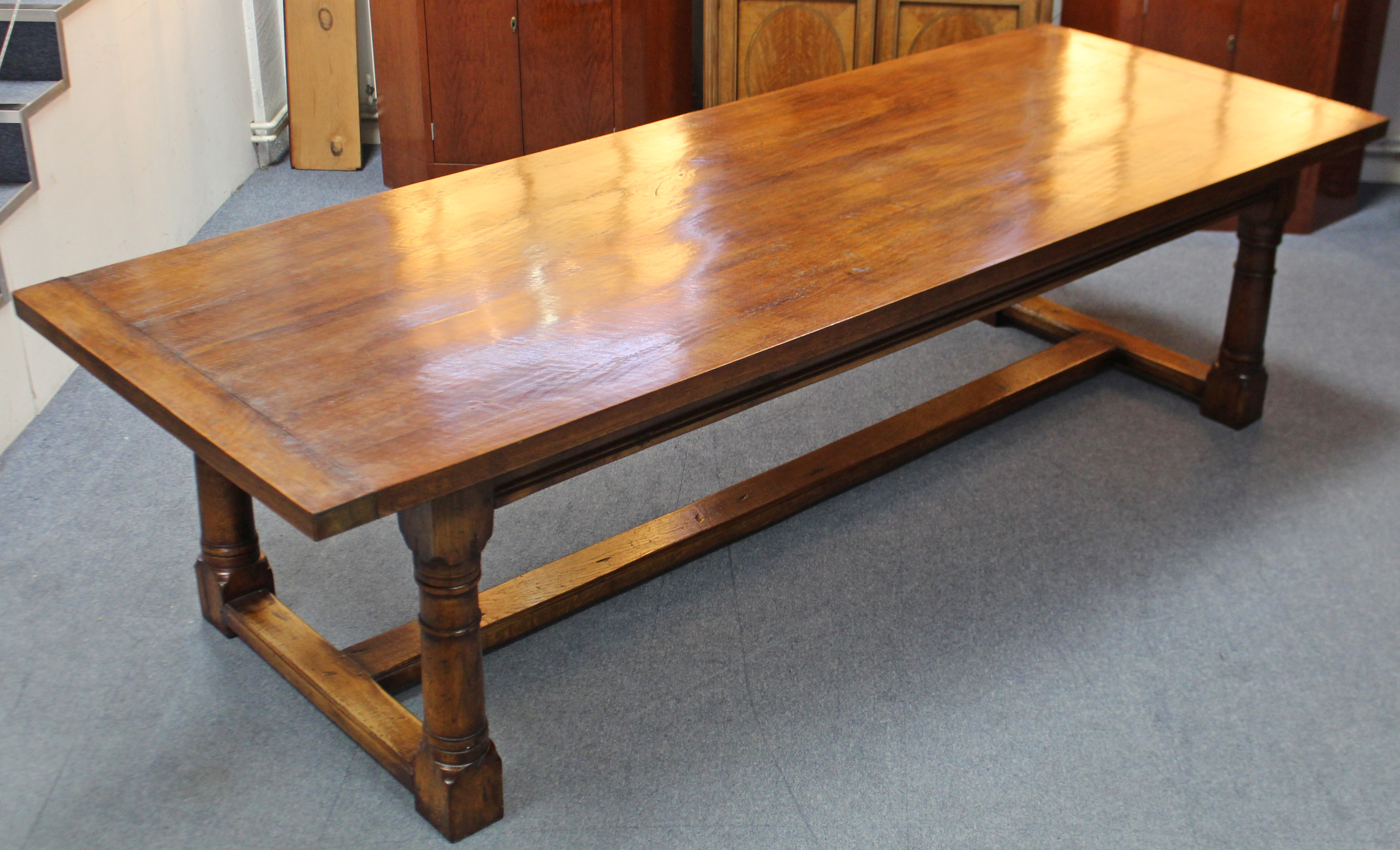 A LARGE 17th century STYLE OAK REFECTORY TABLE, the plain rectangular top with cleated ends above