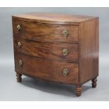 A 19th century mahogany bow-front chest fitted three graduated drawers with brass foliate ring