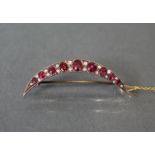 A RUBY, DIAMOND, & GOLD CRESCENT BROOCH, set nine graduated rubies, the largest approximately 0.5