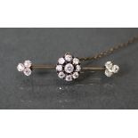 A gold knife-edge bar brooch set diamond cluster, the centre stone approximately 0.25 carat,