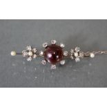 A Victorian gold knife-edge bar brooch set cabochon spinel within a border of eight rose diamonds, a
