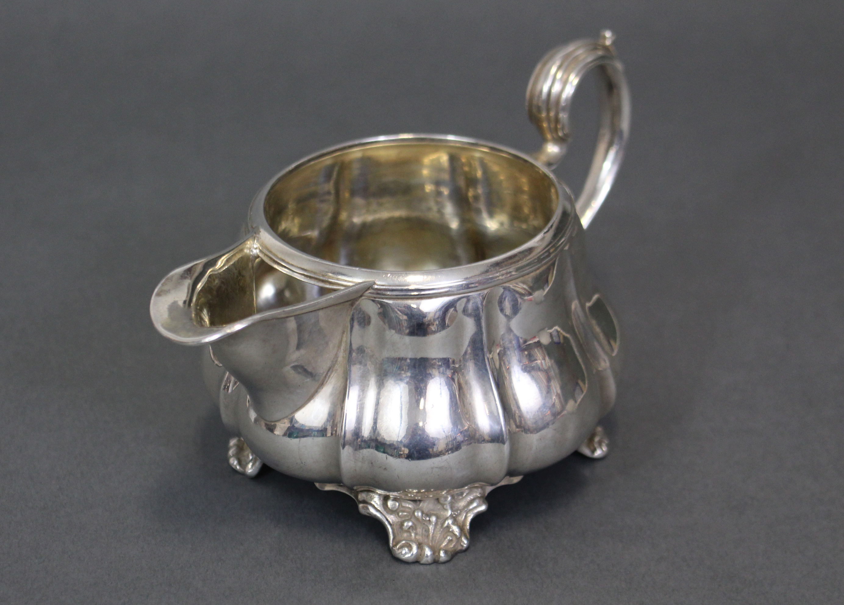 A George IV silver melon-shaped milk jug with moulded scroll handle & on four shell-scroll feet; - Image 2 of 3