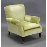 A Victorian armchair upholstered light green material, on short turned legs with brass castors.