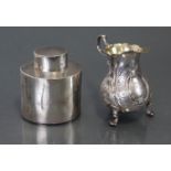 A George III silver ovoid cream jug with card-cut rim, scroll handle & three shell-pad feet,