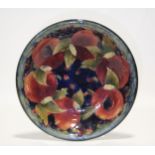A Moorcroft “Pomegranate” shallow circular dish of blue/green ground, painted signature in green &