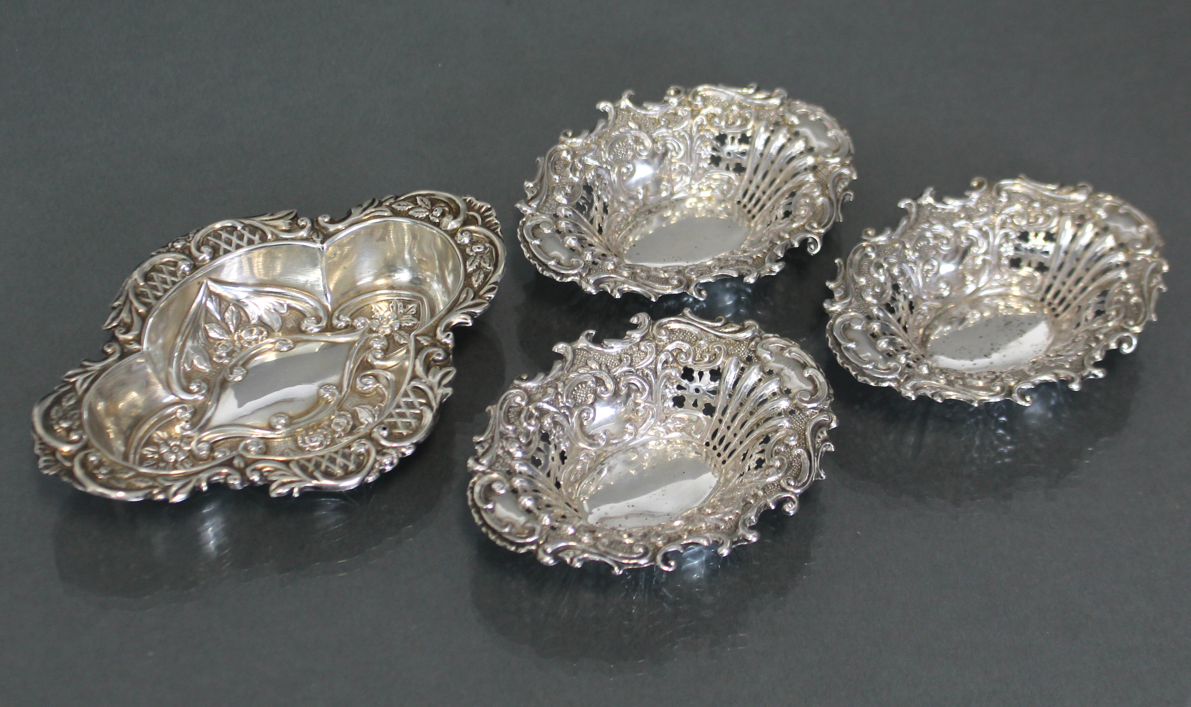 A George V silver quatre-lobe small oval dish with embossed decoration of flowers & scrolls,