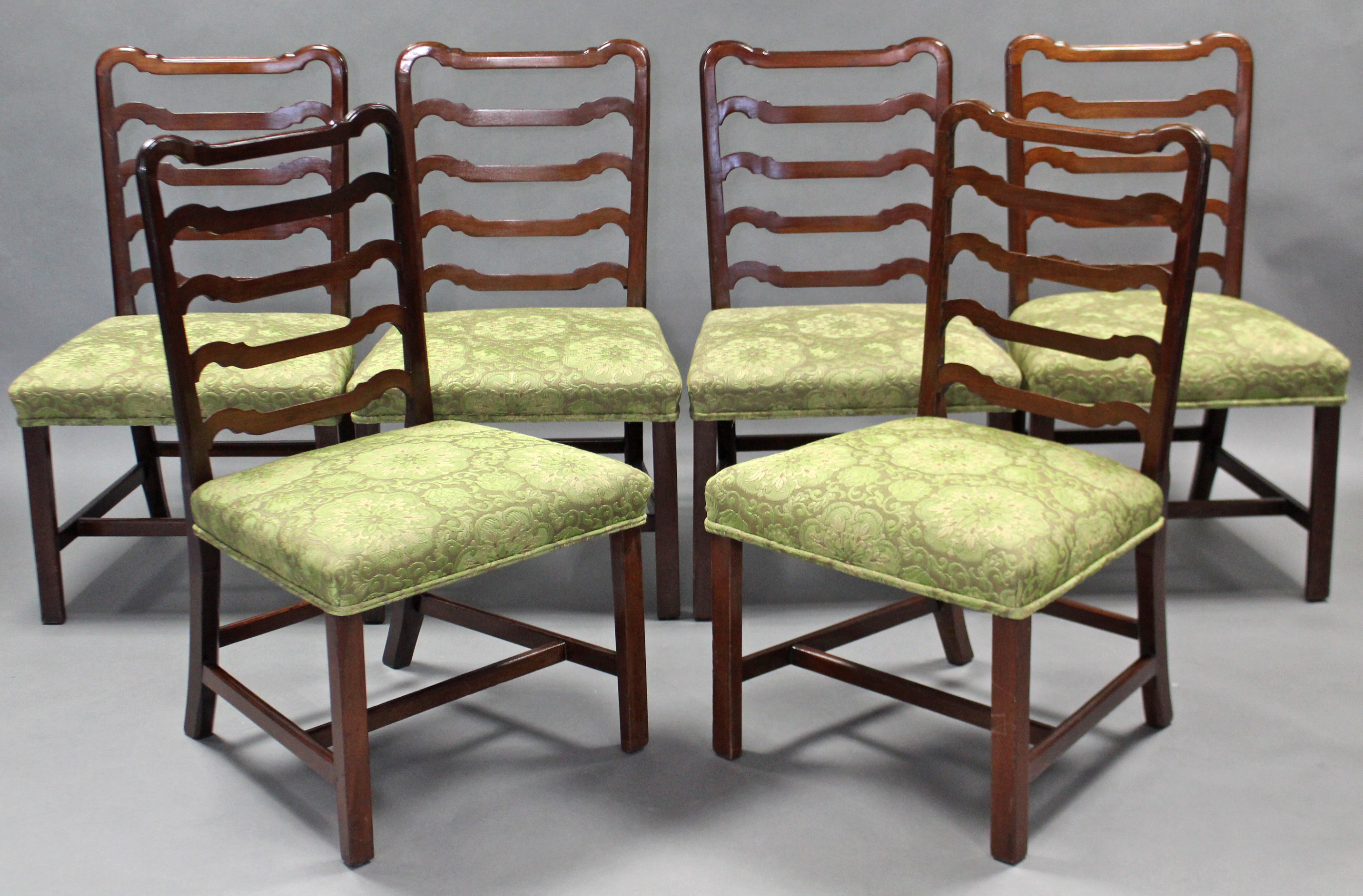 A set of six late 18th century mahogany dining chairs, with shaped ladder backs, padded seats