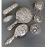 A matched set of Victorian silver-mounted dressing table items with embossed cherub decoration,