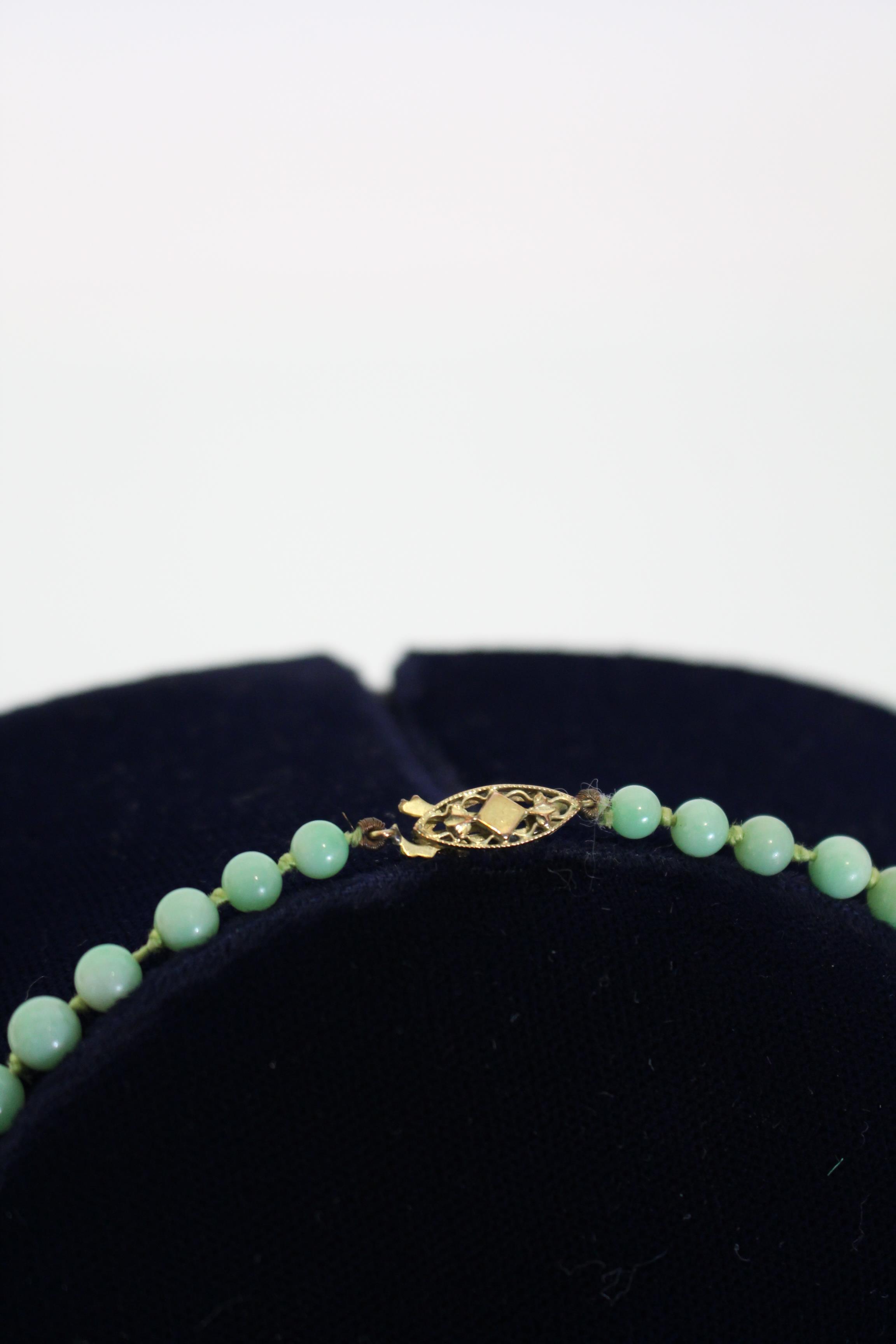 A jade necklace of pale green round graduated beads, the yellow metal pierced oval clasp marked 9ct. - Image 2 of 5