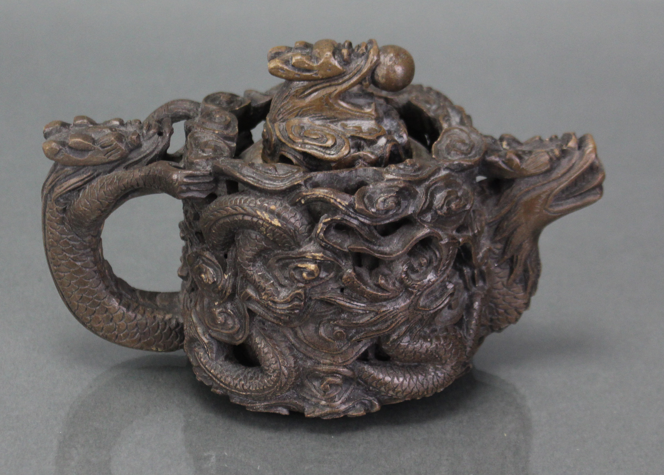 A Chinese soapstone reticulated teapot, deeply carved & pierced with encircling dragons, with